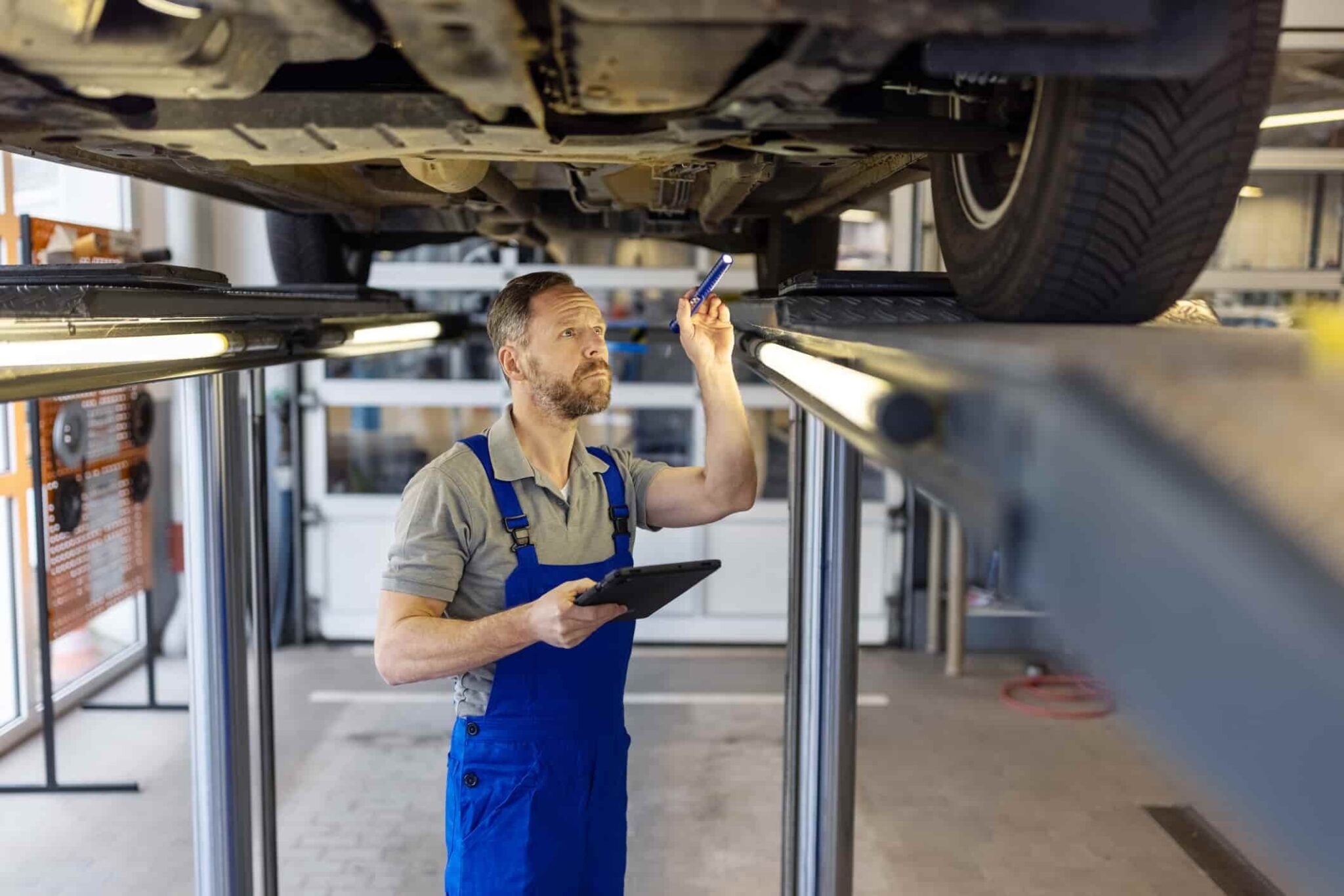 Ireland S Employment Permit System In 2024 What S New   Car Mechanic Checking The Chassis Of The Car On Lift Using A Torch At Garage 2048x1366 