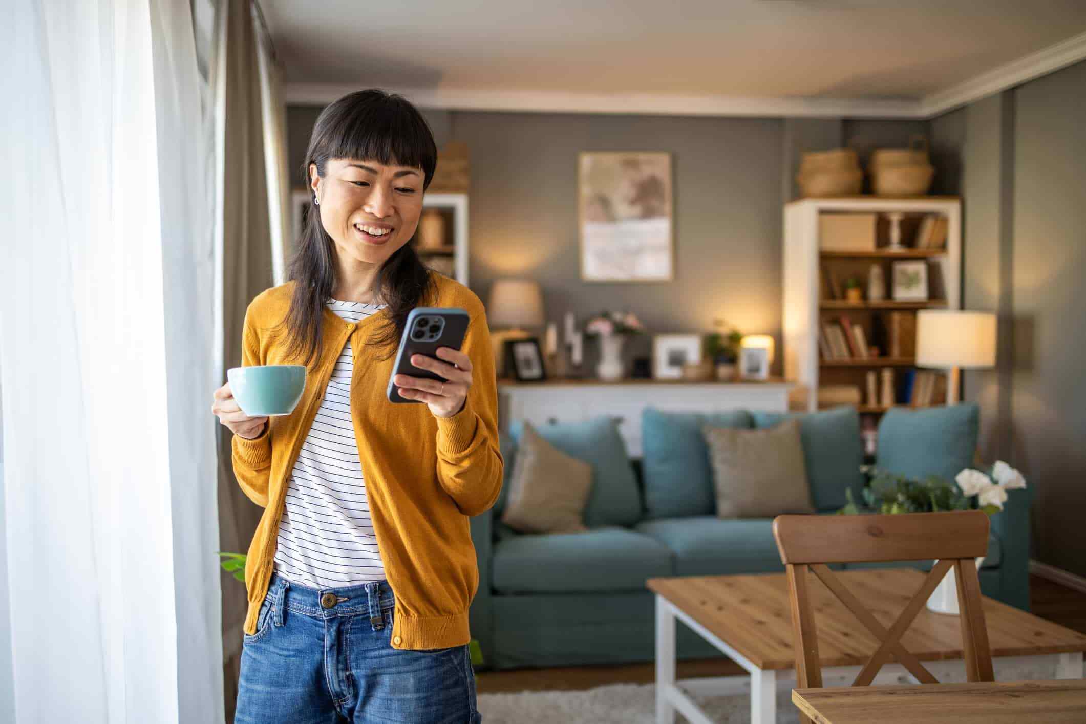 A woman is looking at her phone screen, likely scrolling through social media.